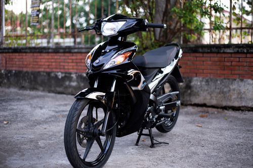 Free A modern black motorcycle parked outdoors in a quaint, quiet spot. Stock Photo