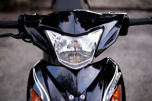 Free Close-up of a sleek black scooter front view, focused on the headlight and handlebars. Stock Photo