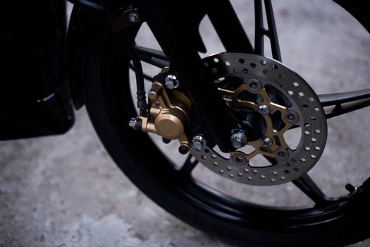 A detailed view of a motorcycle disc brake and caliper showcasing mechanical precision.