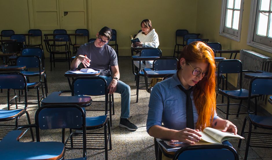 Tres estudiantes estudiando en un aula soleada en Buenos Aires, Argentina.