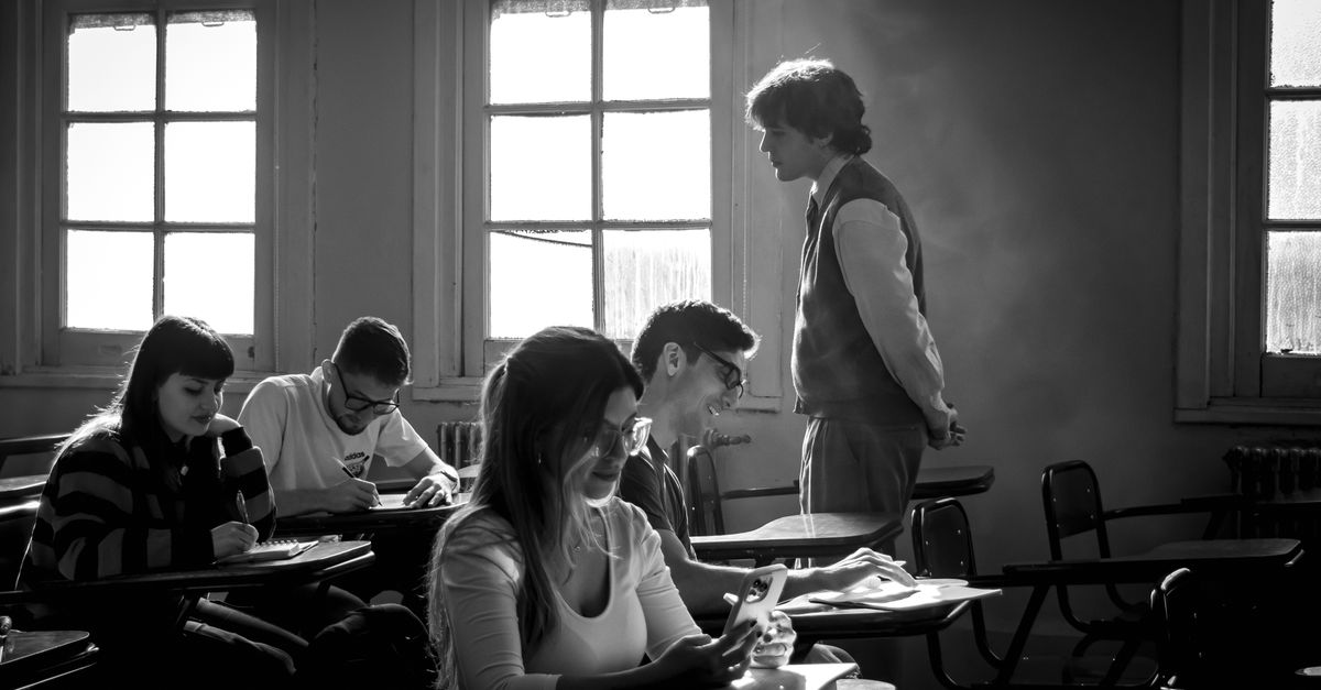 teacher reviewing student assignments in modern classroom