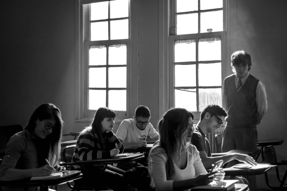教室で教師の指導のもと学習する生徒たち。