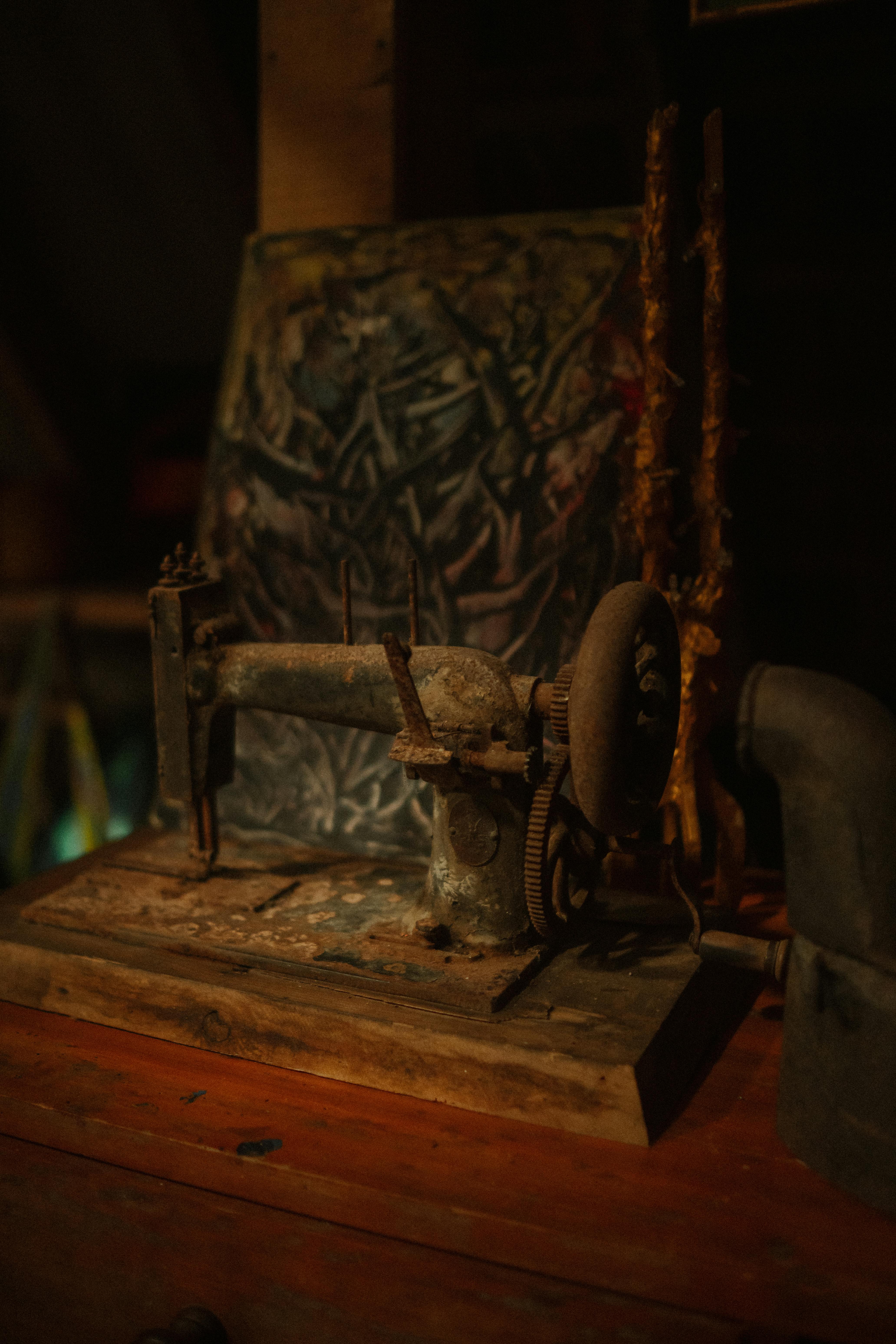A rustic vintage sewing machine set against an artistic backdrop in a dimly lit room for a nostalgic feel.