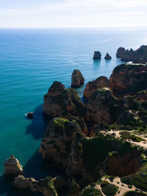 Free A breathtaking aerial view of the iconic Ponta da Piedade cliffs in Lagos, Portugal, basking in sunlight. Stock Photo