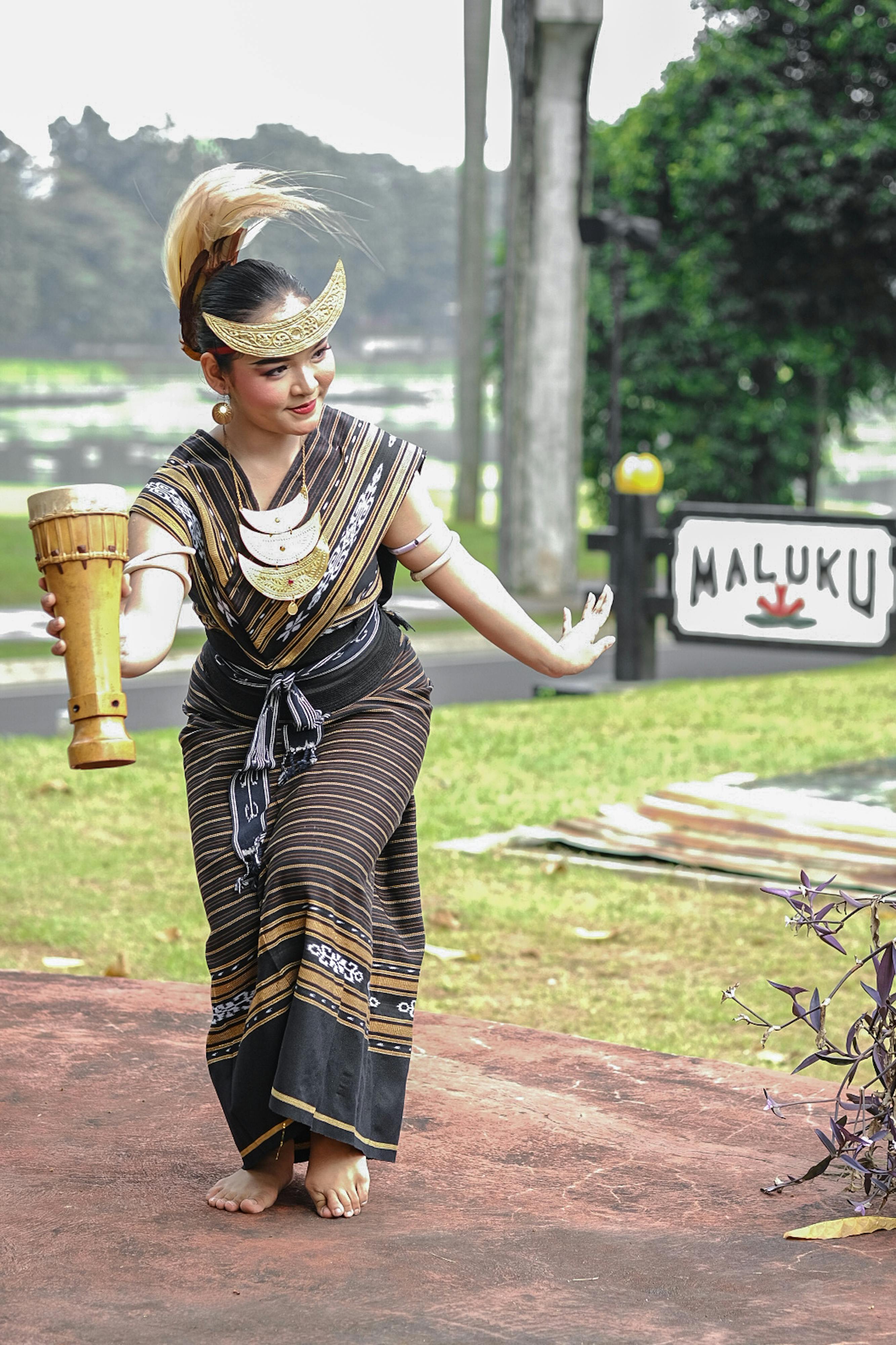 Indonesian dancer in traditional attire performing outdoors in Jakarta.