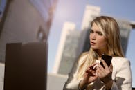 在城市环境中使用笔记本电脑和智能手机工作的职业女性