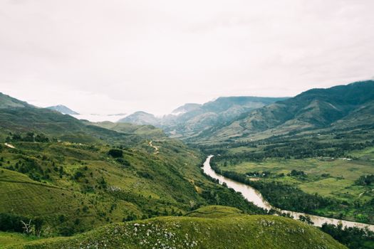 Breathtaking aerial view of lush Papua mountains and winding river.