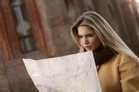 Woman in Brown Long Sleeve Shirt Holding Map