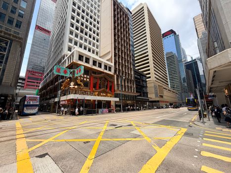 Dynamic city scene showcasing street bustle and iconic architecture in Hong Kong's Central area.