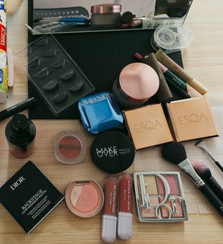 A flat lay of various makeup products on a wooden table, perfect for beauty themes.