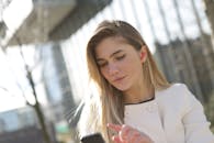 现代城市中，时尚女性在户外使用智能手机