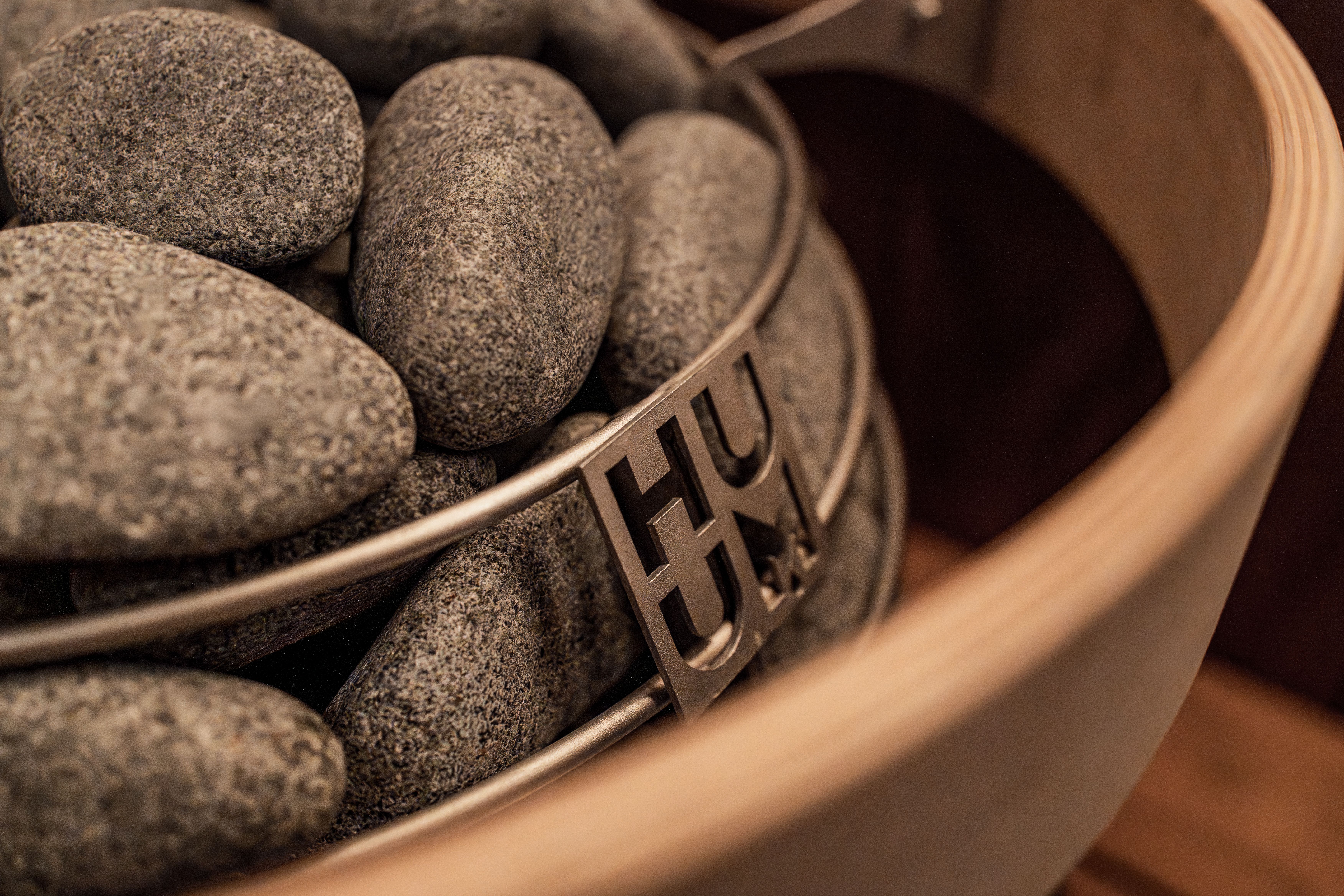 Close-up view of a modern sauna heater with stones, showcasing Nordic design elements and an aesthetic vibe.