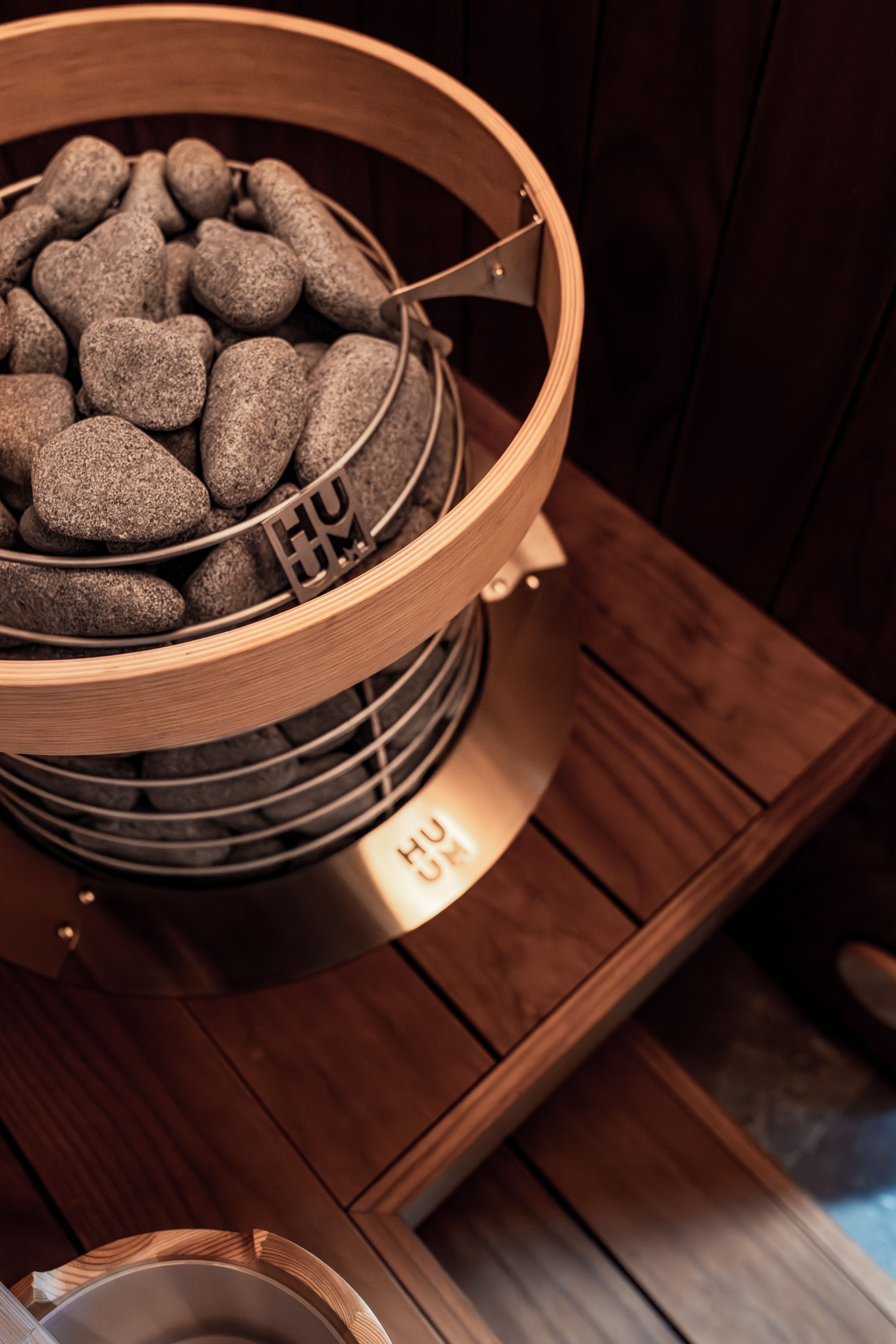 Stylish indoor sauna featuring a HUUM electric heater with natural stones for a modern Nordic design.