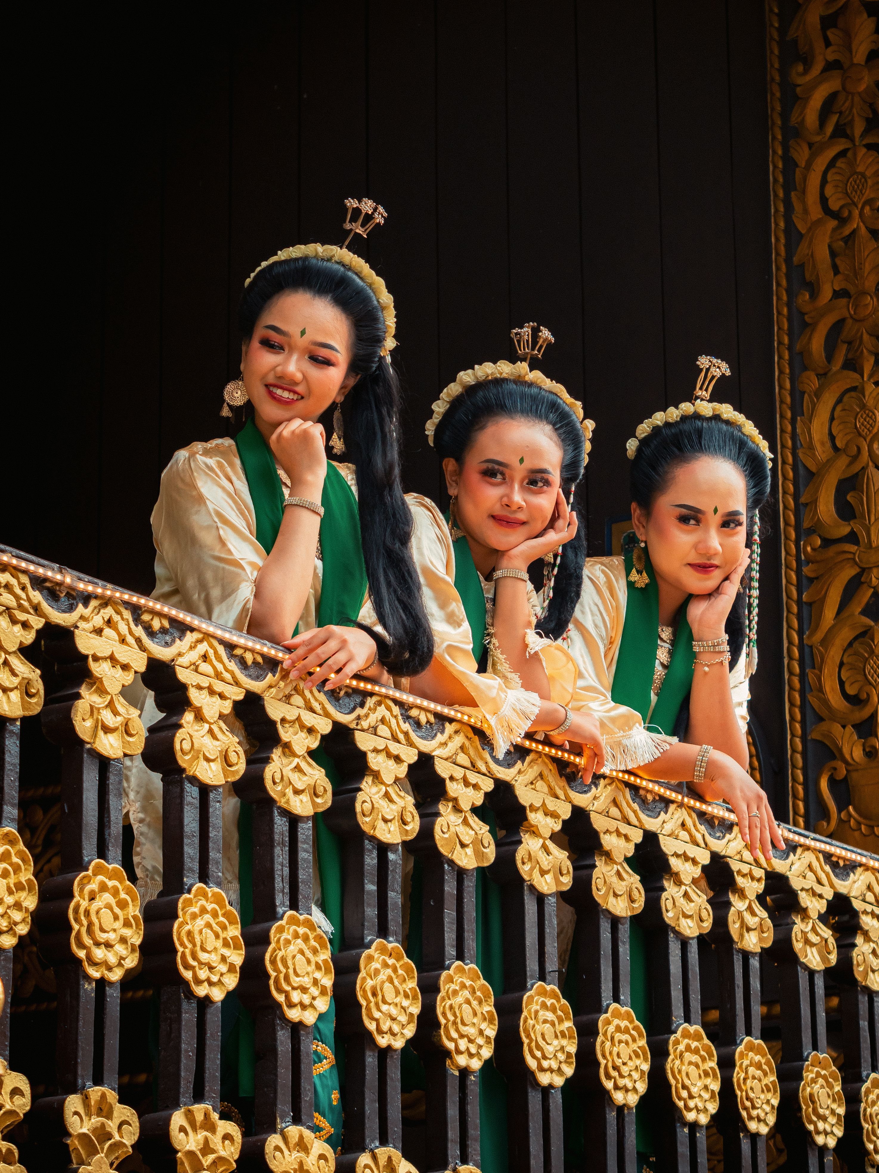 Three women in traditional Indonesian attire on a decorated balcony in Jakarta.