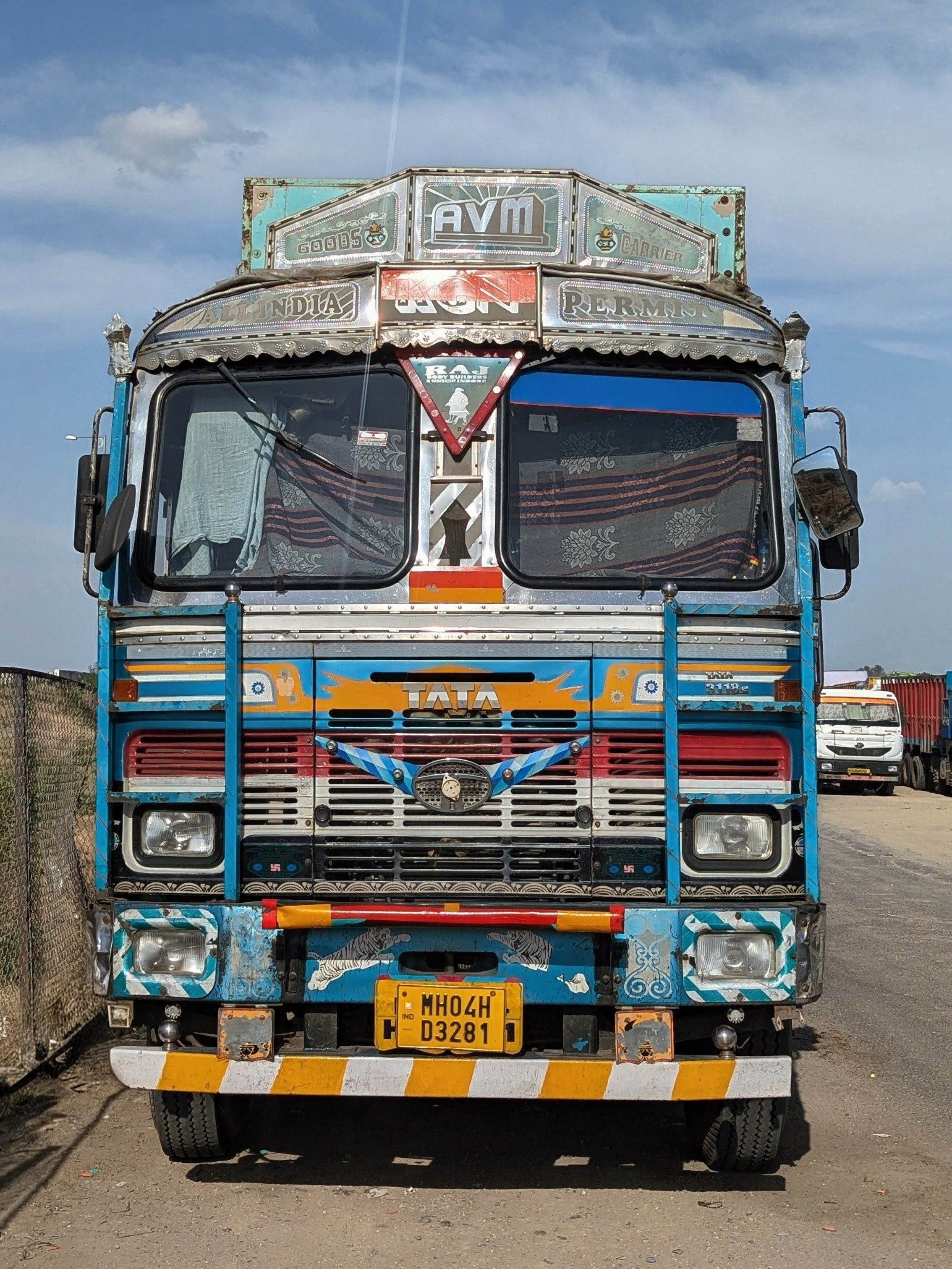 Vibrant Indian truck with ornate decorations parked on a sunny day.