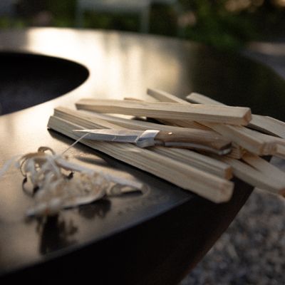 Whittling knife and wood shavings beside a fire pit — photo by River Augustin on Pexels