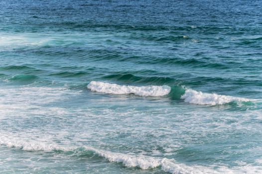Tranquil ocean waves gently crashing on a beach, capturing the serene Irish coastline.