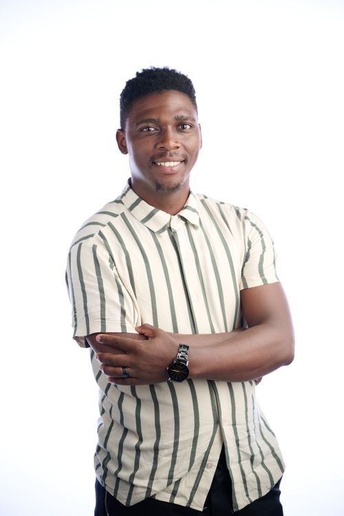 Free Portrait of a smiling young adult wearing a striped shirt, isolated on white background. Stock Photo