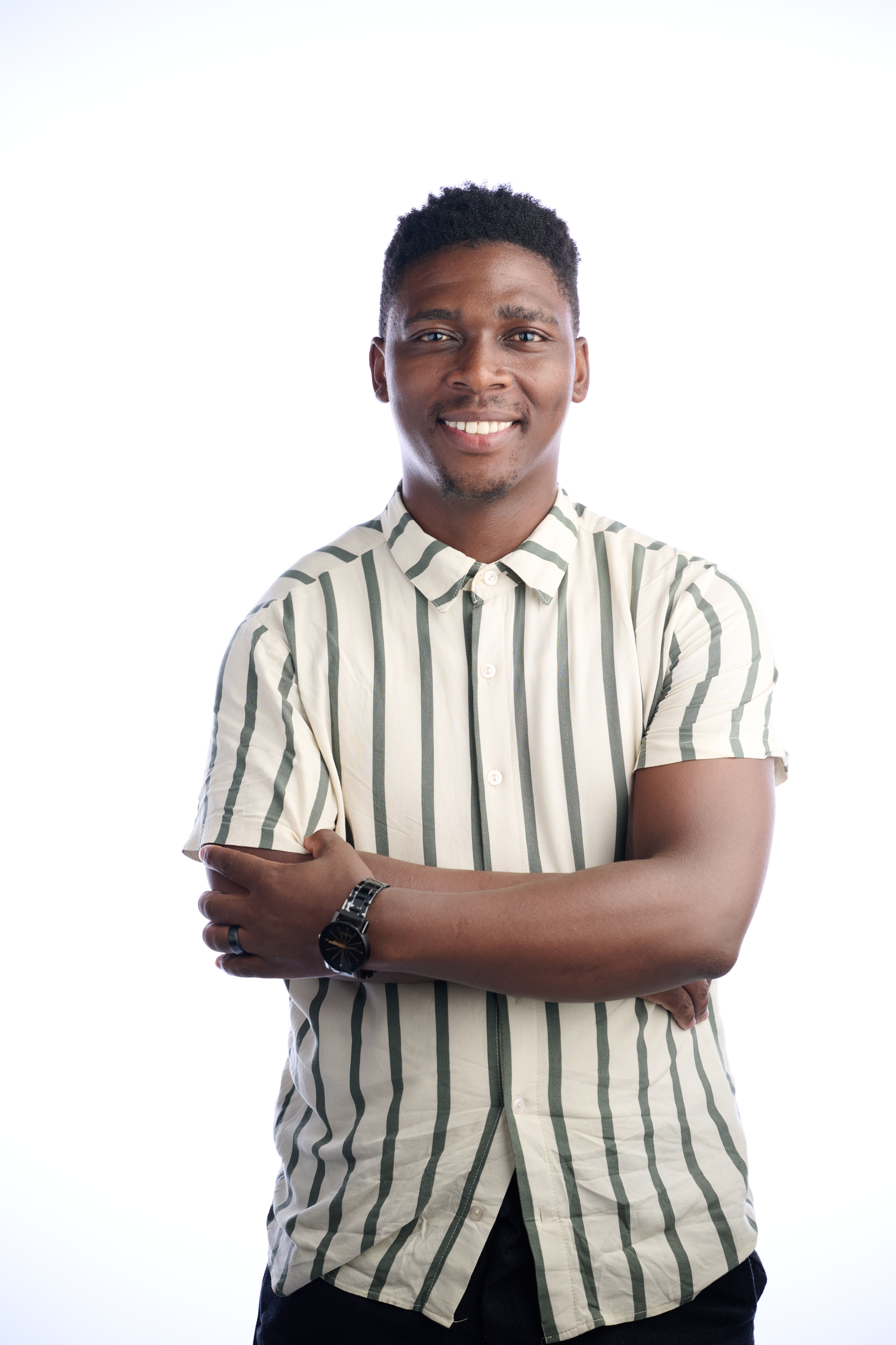 Smiling man wearing a striped shirt posing against a white background. Studio portrait.