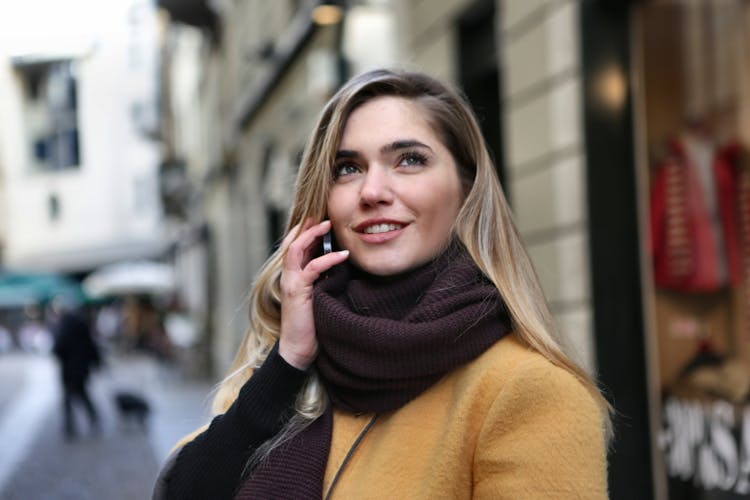 Woman In Brown Scarf And Black Coat Looking Up The Sky