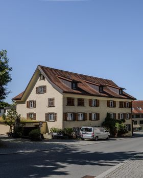 Traditional European house with wooden shutters under a clear blue sky.