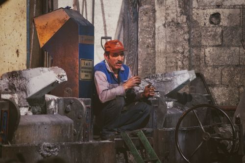 Free A worker takes a break in an industrial factory setting, showcasing the gritty environment. Stock Photo