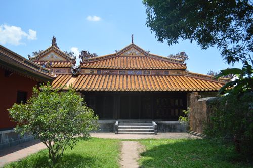 Free A traditional Vietnamese temple with ornate architecture and orange tiled roof on a sunny day. Stock Photo