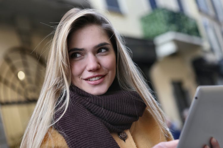 Woman Wearing Brown Coat And Maroon Scarf Holding Ipod