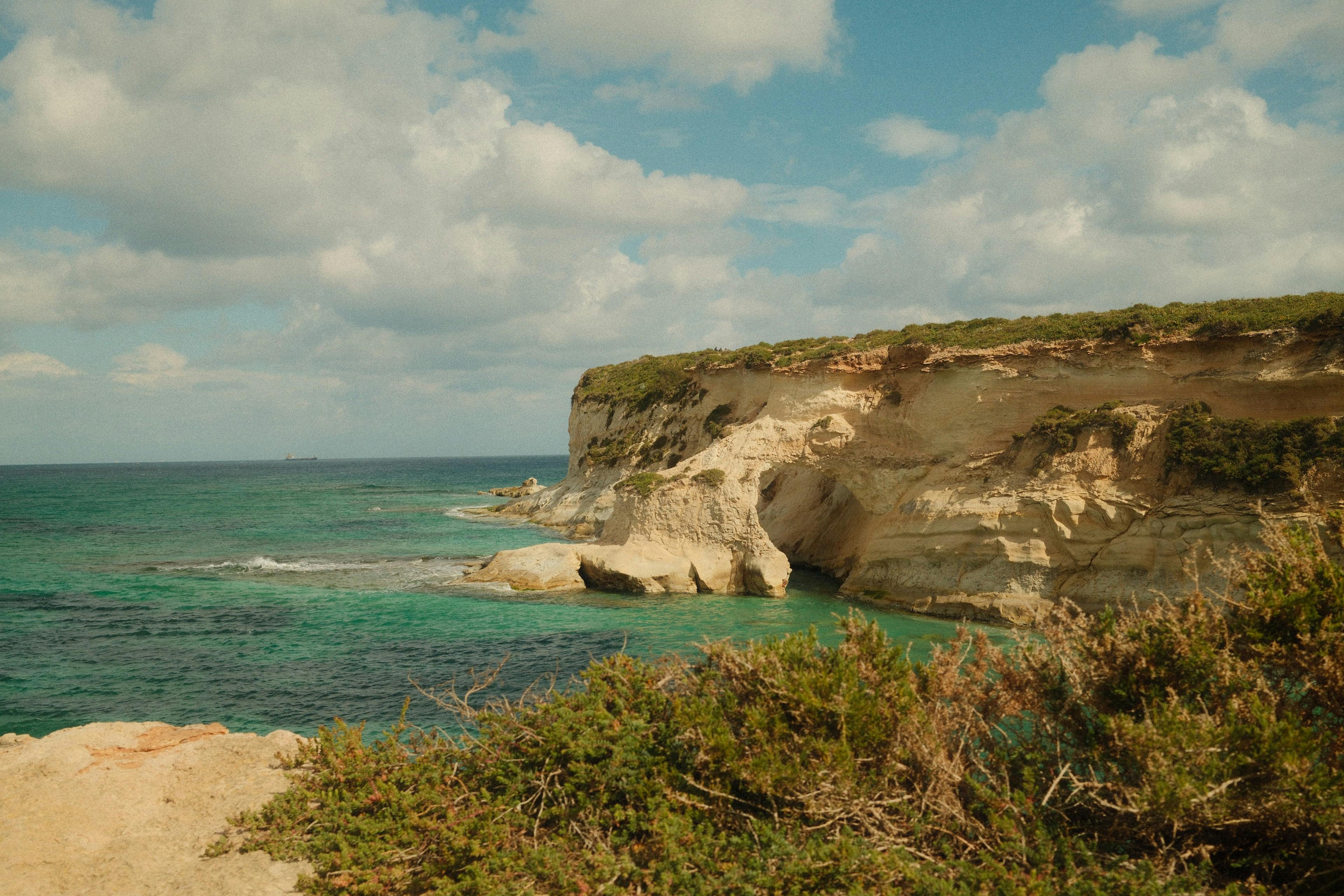 Stunning view of Maltese cliffs and turquoise waters under a blue sky. - Photo by Alyona Nagel on Pexels