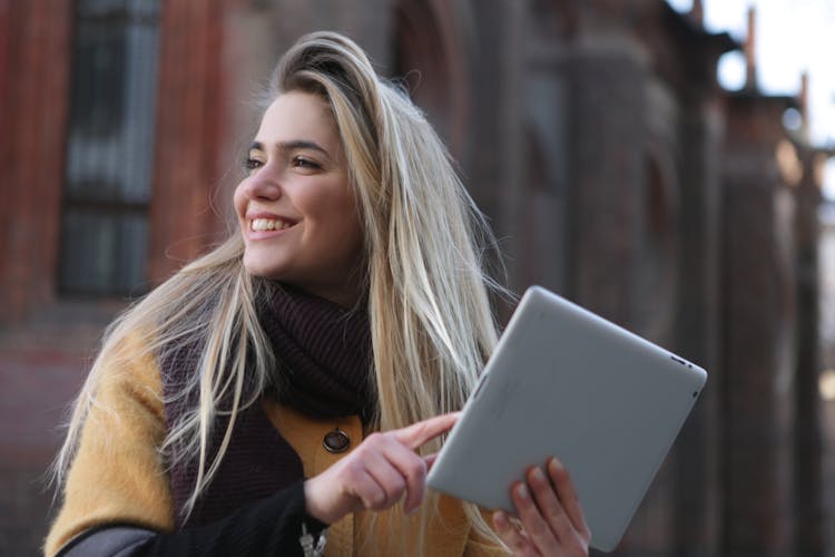 Woman In Brown Coat Holding Silver Ipad