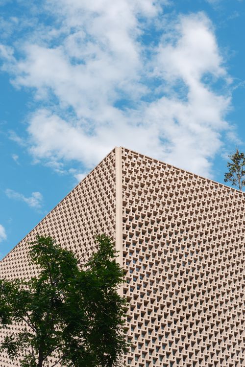 Free A contemporary triangular-patterned building shot against a vibrant blue sky with clouds in Istanbul, Türkiye. Stock Photo