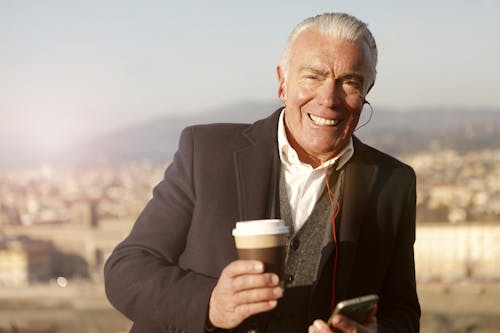 Man In Black Suit Holding A Coffee