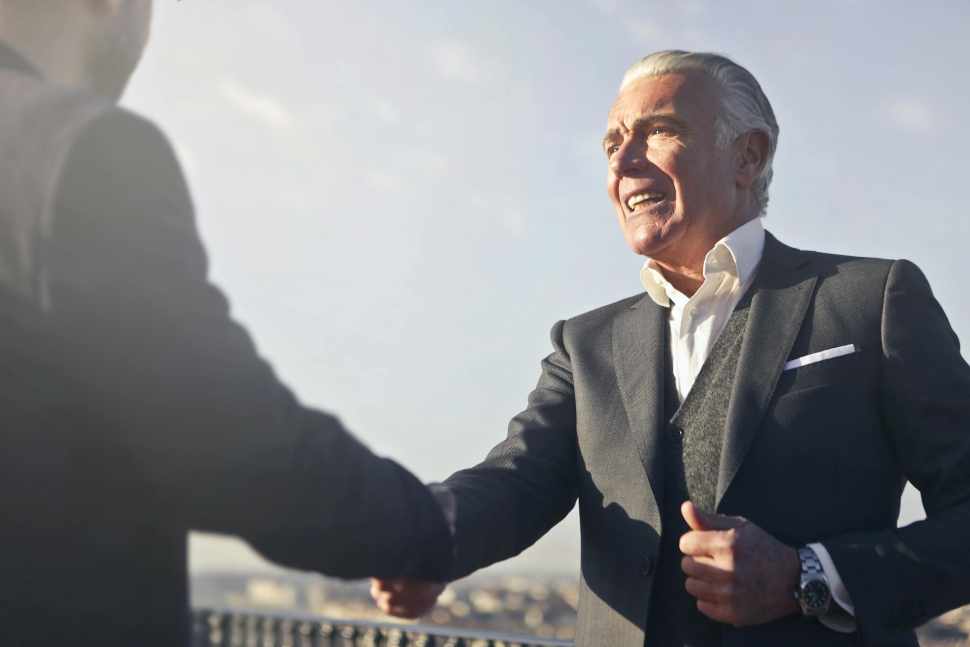 Man in Black Suit Shaking Hands with Another Man