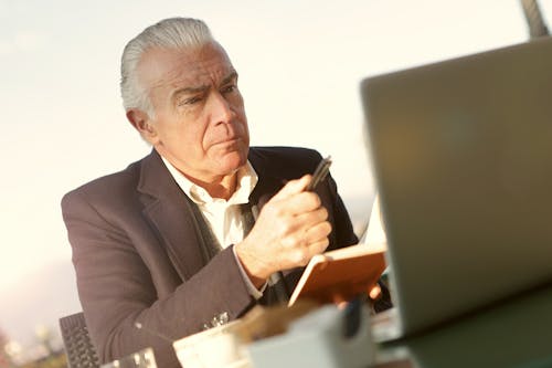 Free Man in Black Suit Holding A Pen Stock Photo