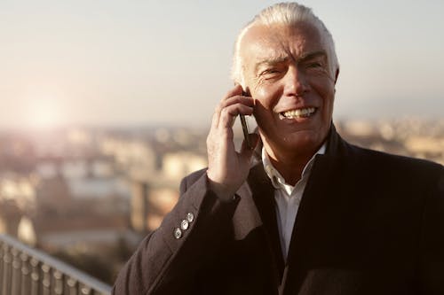 Man In Black Suit Jacket Holding Phone