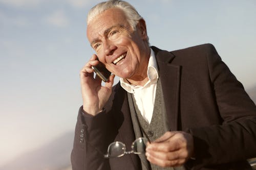 Man In Black Suit Jacket Holding A Eyeglasses