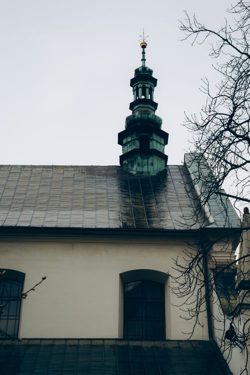 Free A classic church steeple rises against a cloudy sky in Krakow, showcasing timeless architecture. Stock Photo