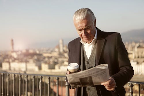 Free Man In Black Suit Reading Newspaper Stock Photo