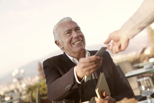 一位年长男子在户外微笑着递上信用卡，体现了信任与互动