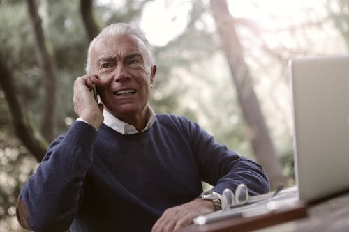 Man In Blue Sweater Talking To Someone