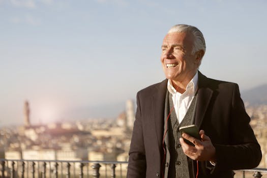 Elderly man smiles while using smartphone outdoors, embracing modern technology.