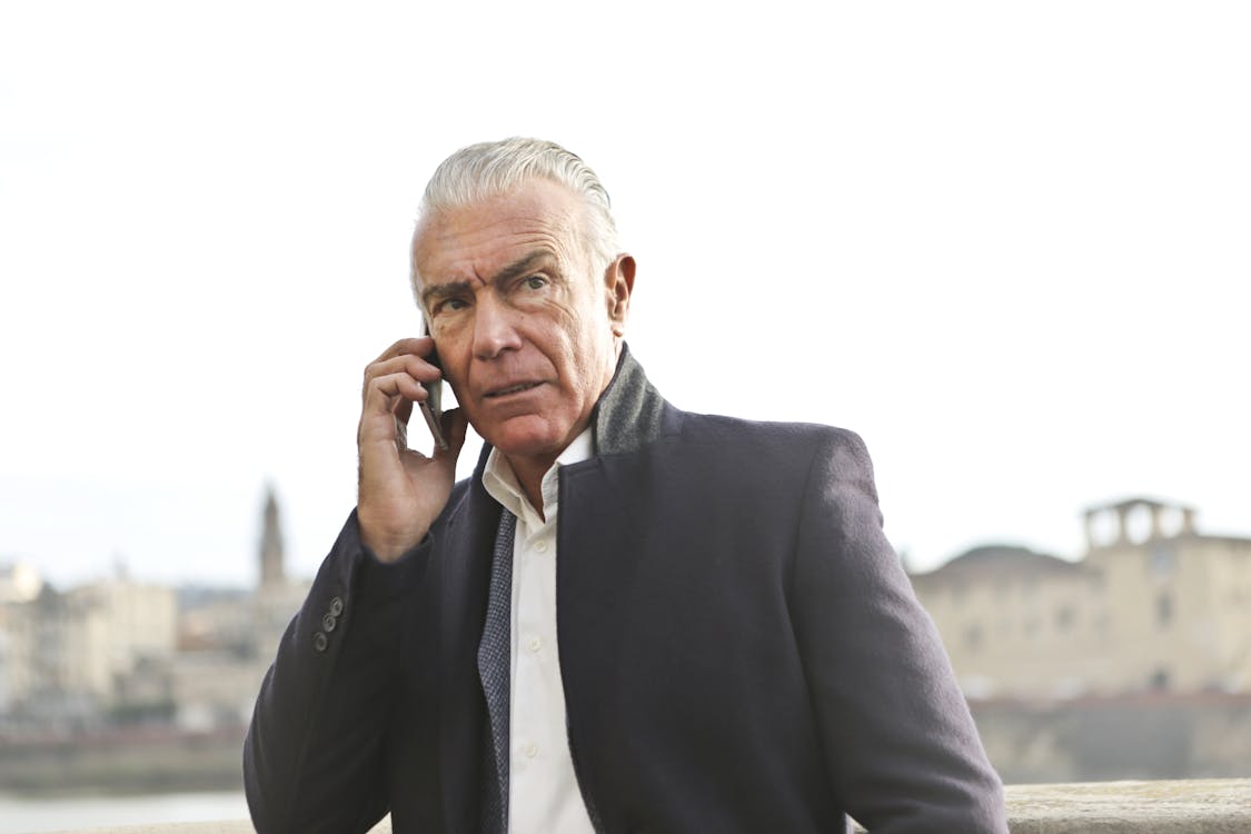 Man in Black Suit  Using A Cellphone