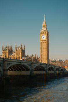 The majestic Big Ben stands by the River Thames on a bright day in London, showcasing historic architecture.