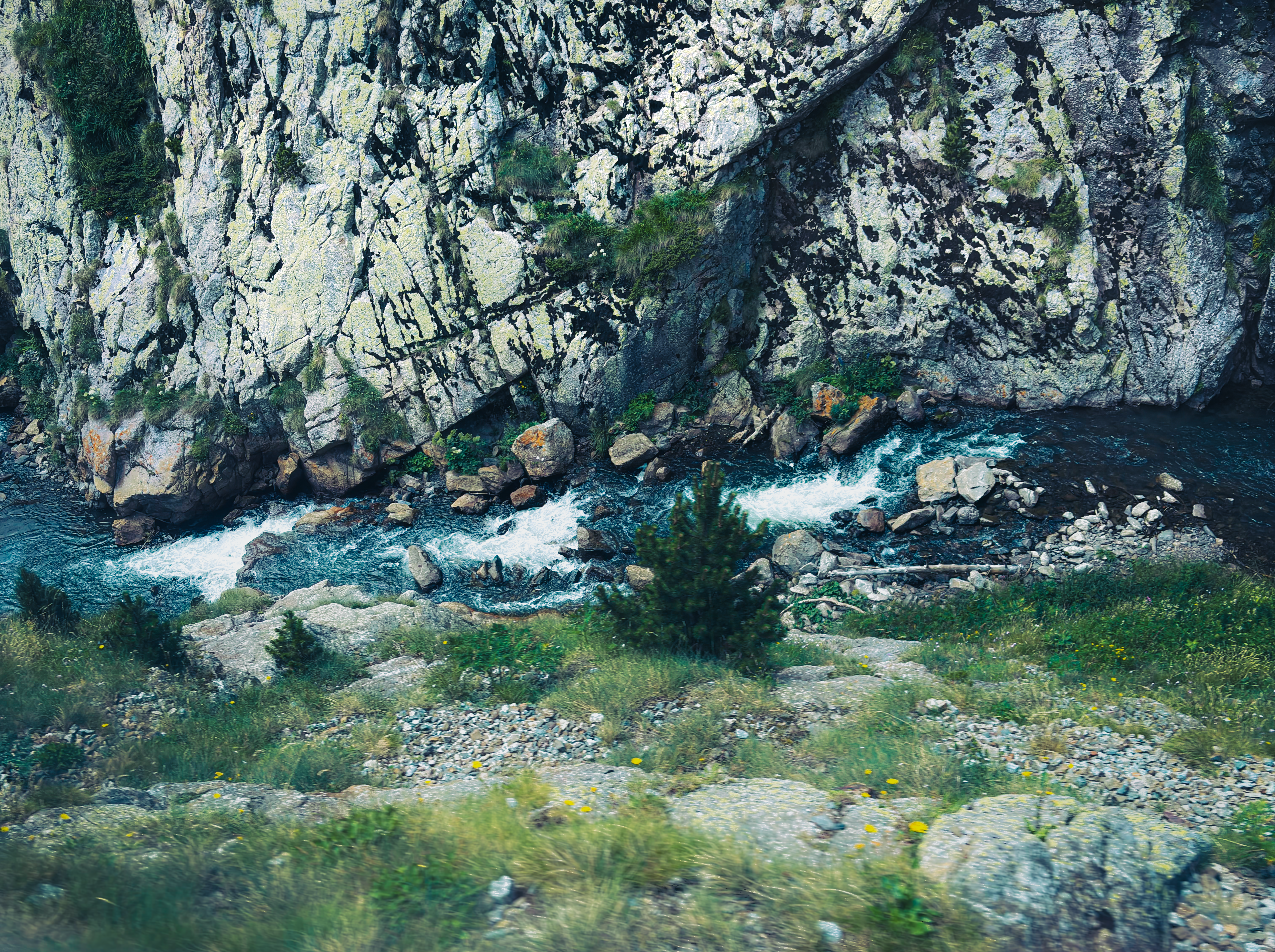 Serene mountain river flowing through rocky landscape in Núria, Catalonia, Spain.