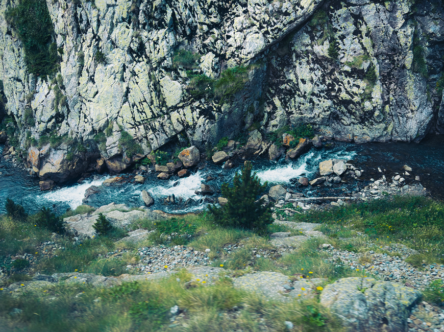 Serene mountain river flowing through rocky landscape in Núria, Catalonia, Spain.