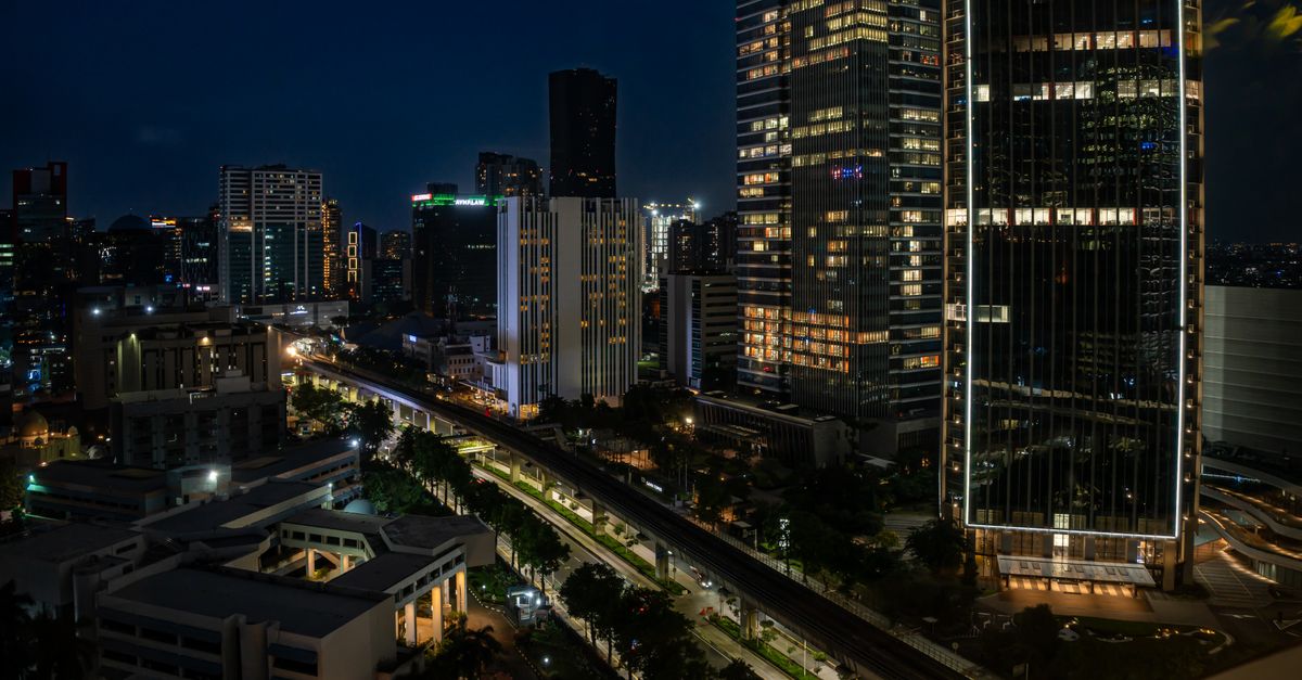 Captivating view of Jakarta's cityscape featuring illuminated skyscrapers against a night sky.