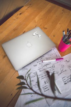 一张配有笔记本电脑、笔记本和笔的整洁木制办公桌，营造出井然有序的工作环境