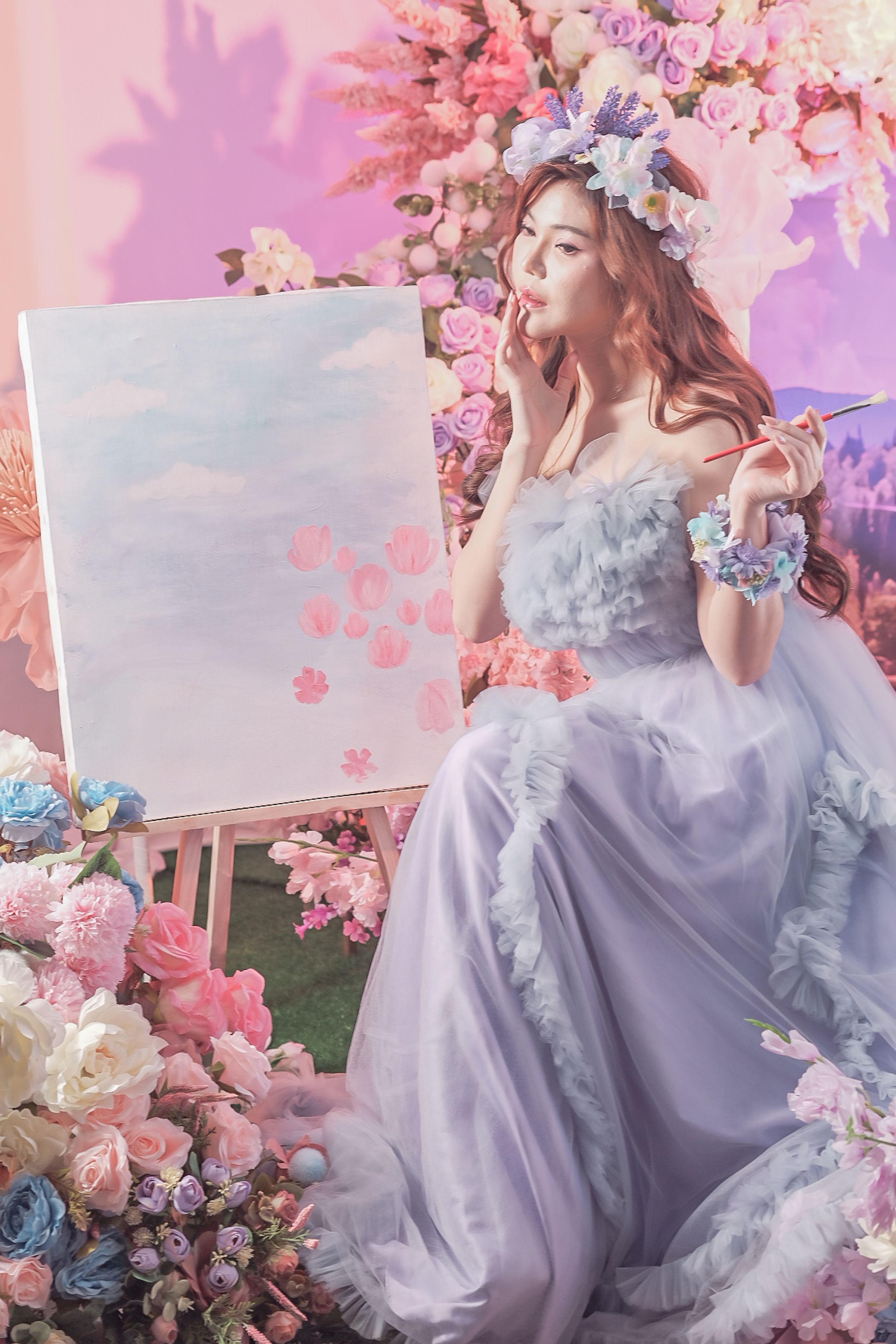 Woman in a lavender gown painting amidst vibrant flowers, exuding a dreamy, artistic vibe.