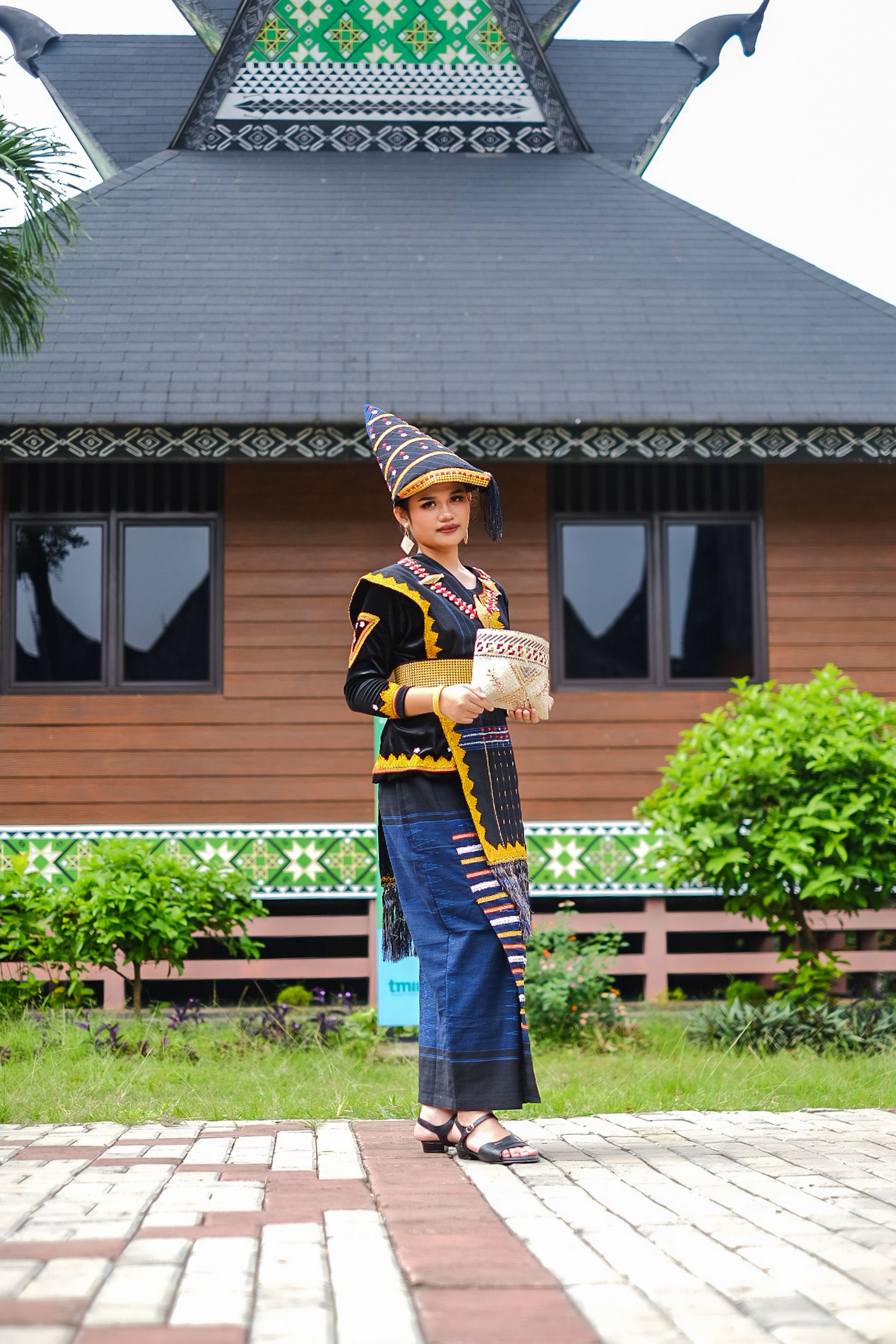 Gratuit Femme en tenue traditionnelle indonésienne devant une architecture caractéristique de Jakarta, mettant en valeur le patrimoine culturel. Photos