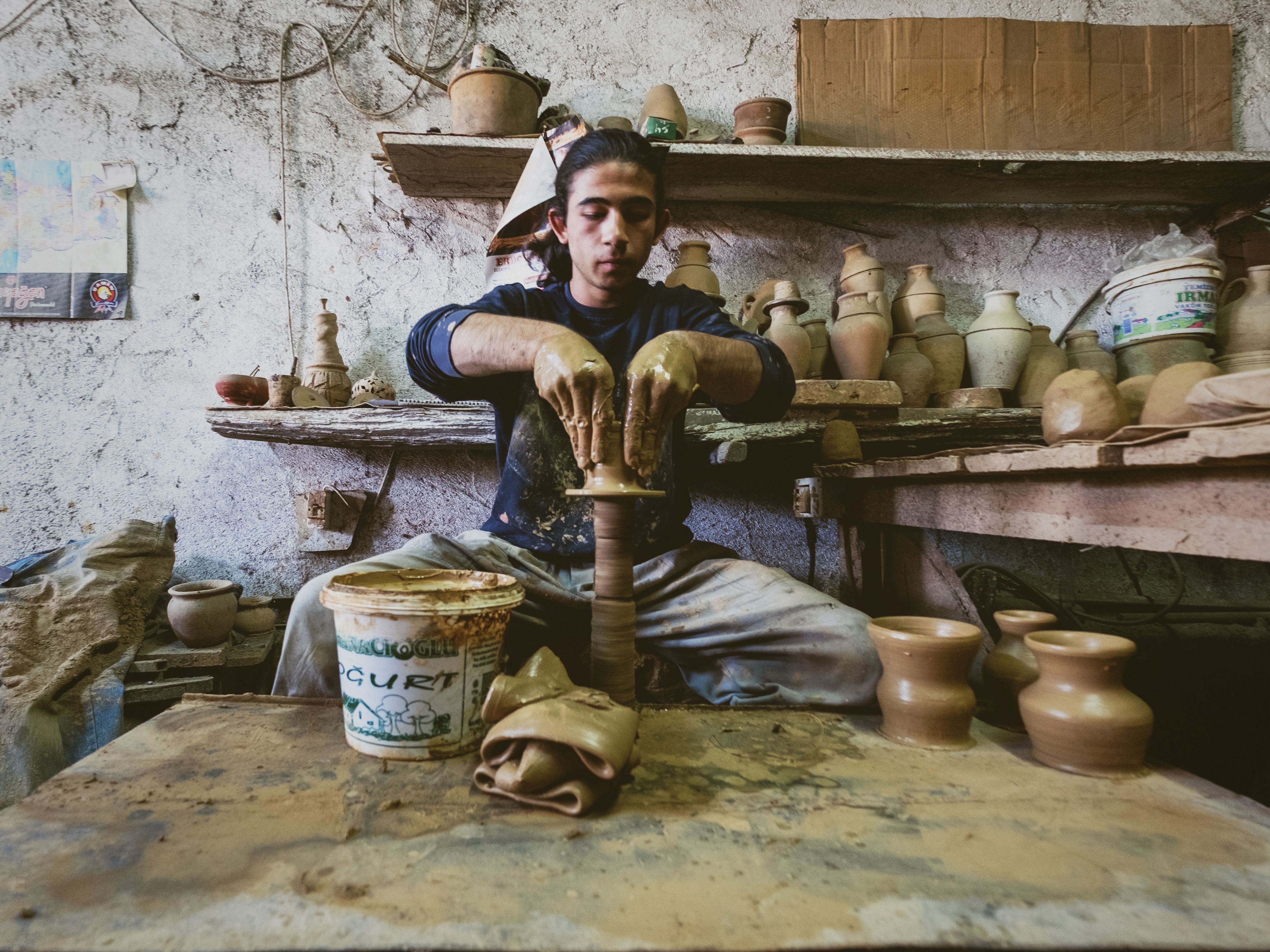 Skilled Potter Crafting Clay Pots in Rustic Workshop